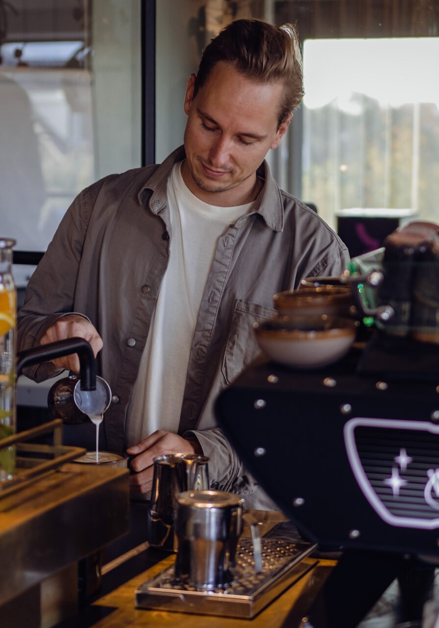 Silvan Laroo met een kopje espresso naast zijn machine