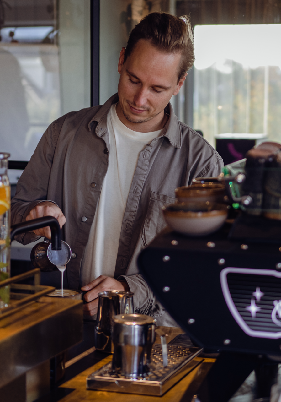 Silvan Laroo met een kopje espresso naast zijn machine